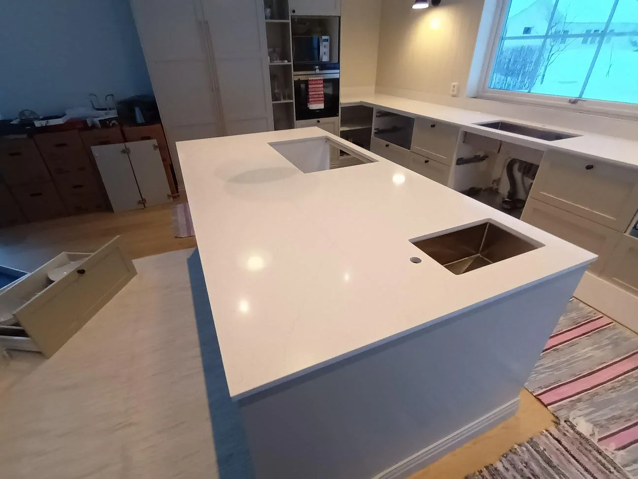 Polerad vit Silestone Eternal Statuario sedd ovanifrån med underlimmad rostfri diskho och hällurtag på köksön i Leksand.