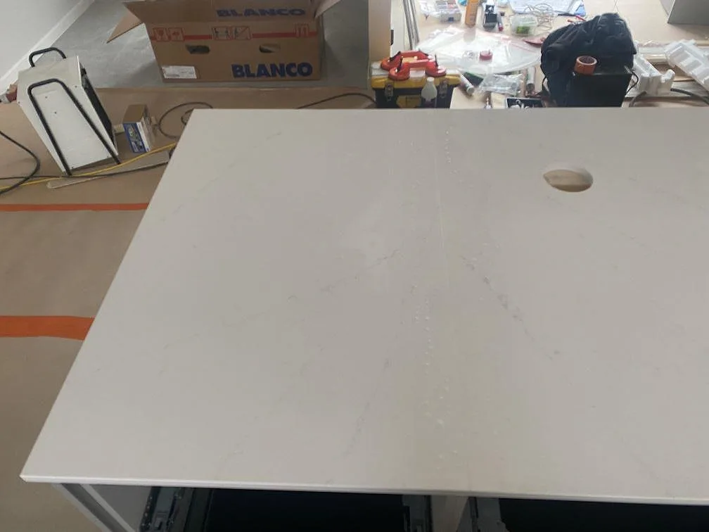 Polerad vit Silestone Eternal Statuario bänkskiva med runt blandarhål och synlig ådring i kök i Ljungby.