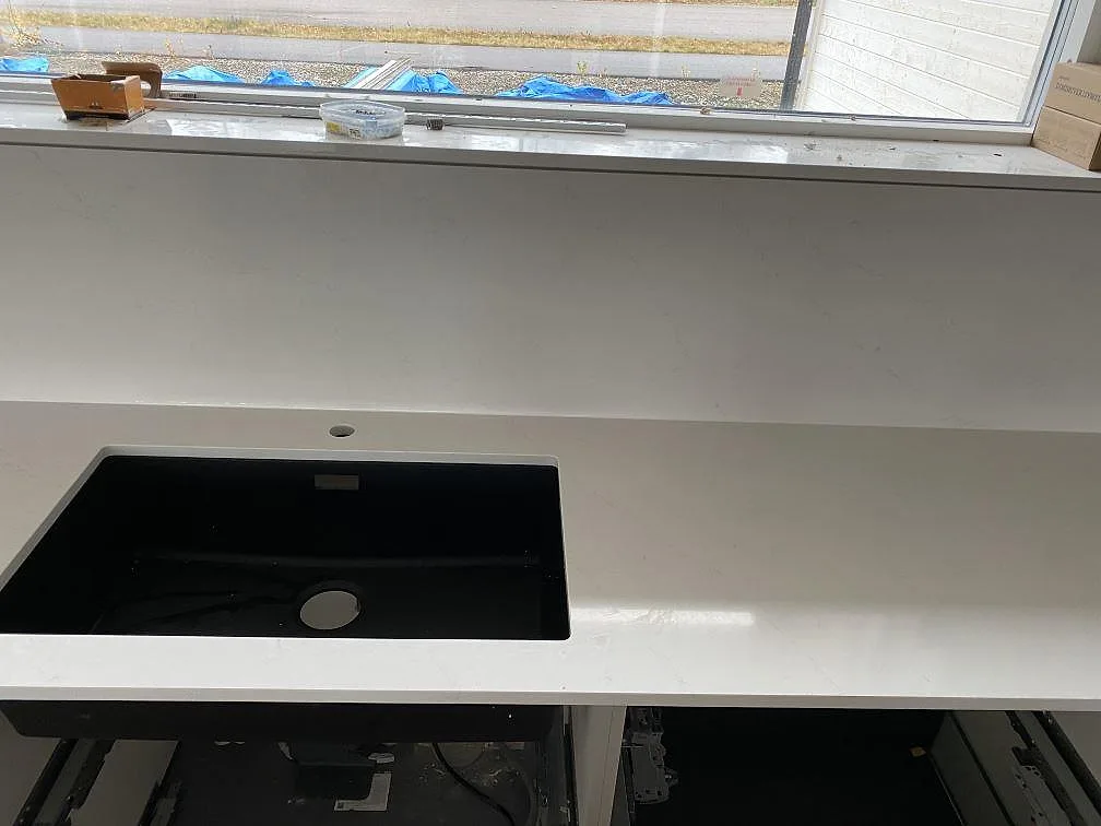 Polerad Silestone Eternal Statuario bänkskiva med svart diskho, blandarhål och 12mm stänkskydd under fönster i kök i Ljungby.