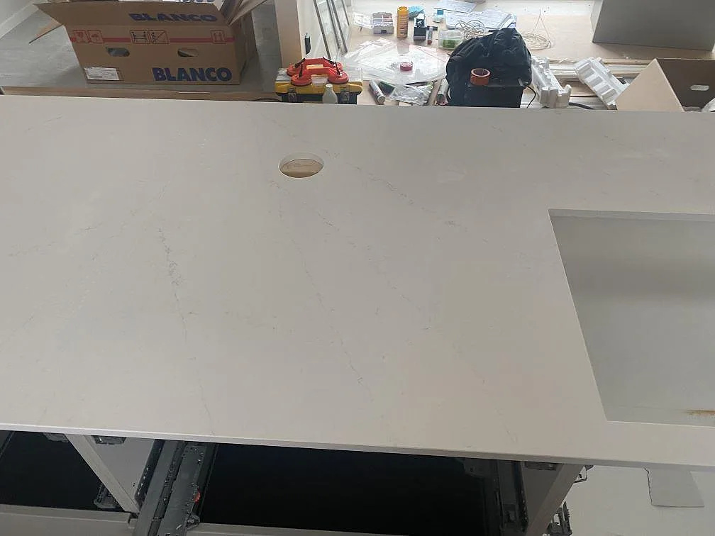 Närbild på polerad Silestone Eternal Statuario med blandarhål och urtag för diskho under köksmontering i Ljungby.