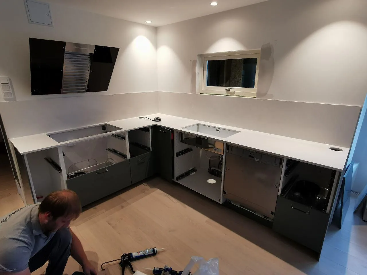U-formad köksbänkskiva i vit Silestone Eternal Statuario, polerad komposit med stänkskydd i ett kök i Löddeköpinge.