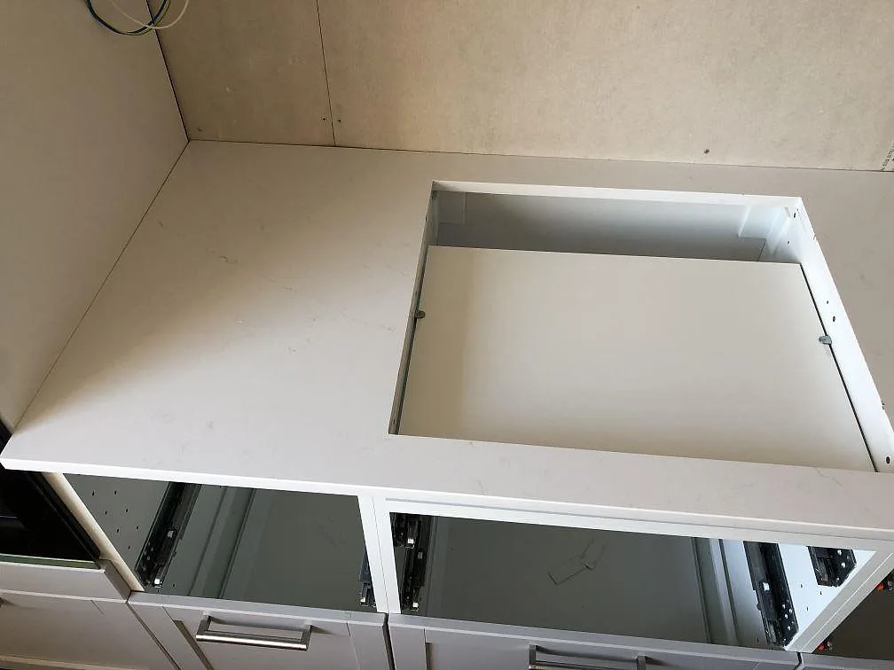 Vit Silestone Eternal Statuario bänkskiva med urtag för övermonterad spishäll, polerad yta, i ett kök i Malmö under montering.