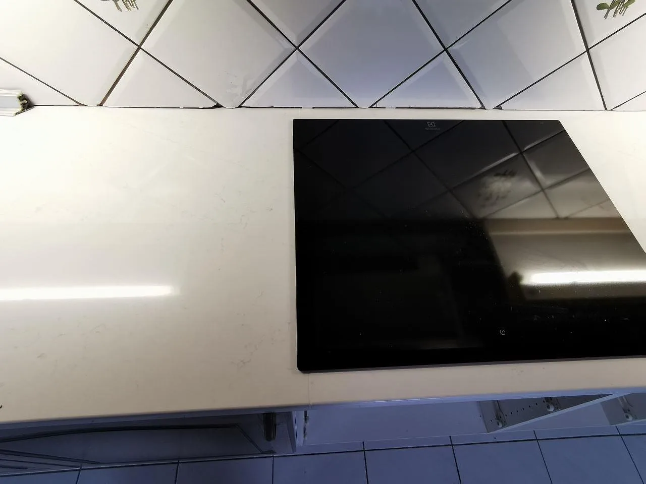 Bänkskiva i Silestone Eternal Statuario med övermonterad svart Electrolux induktionshäll i ett kök i Malmö.