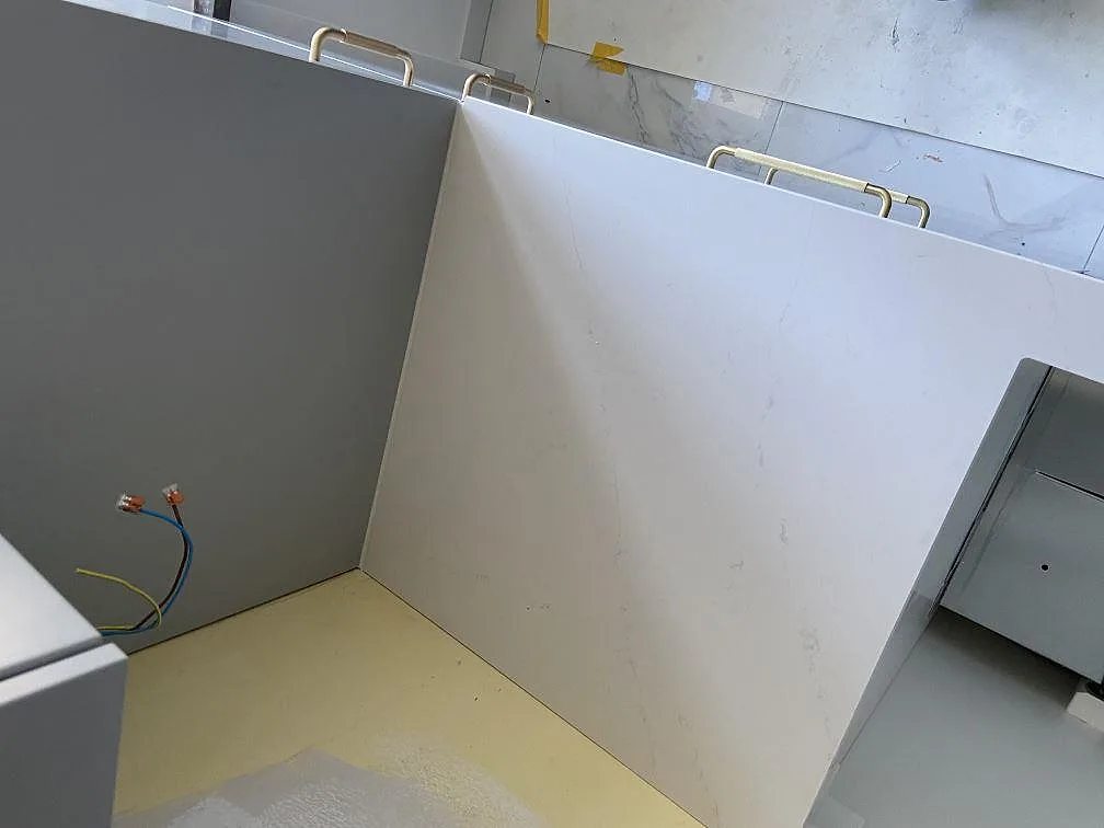Uppvikt stenparti i vit Silestone Eternal Statuario i en innerhörna under montering i ett kök i Malmö.