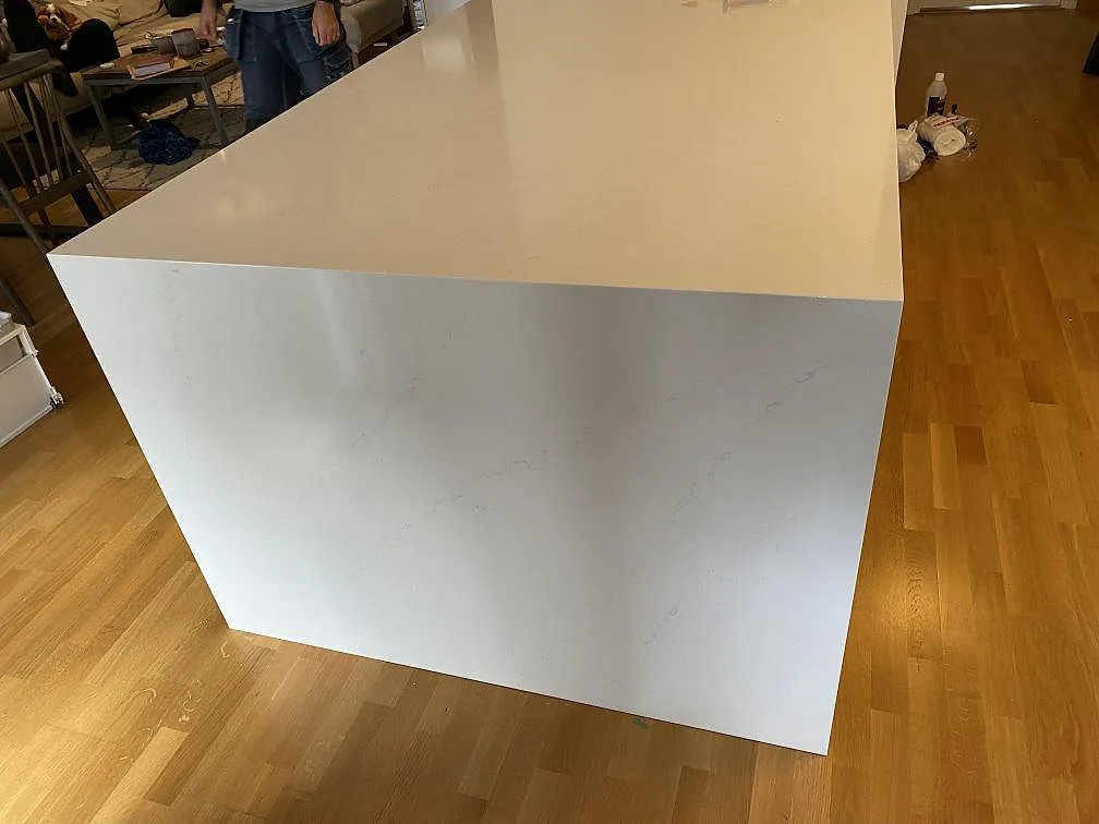 Köksö i vit Silestone Eternal Statuario med heltäckande stensida ned mot golvet i ett kök i Malmö.