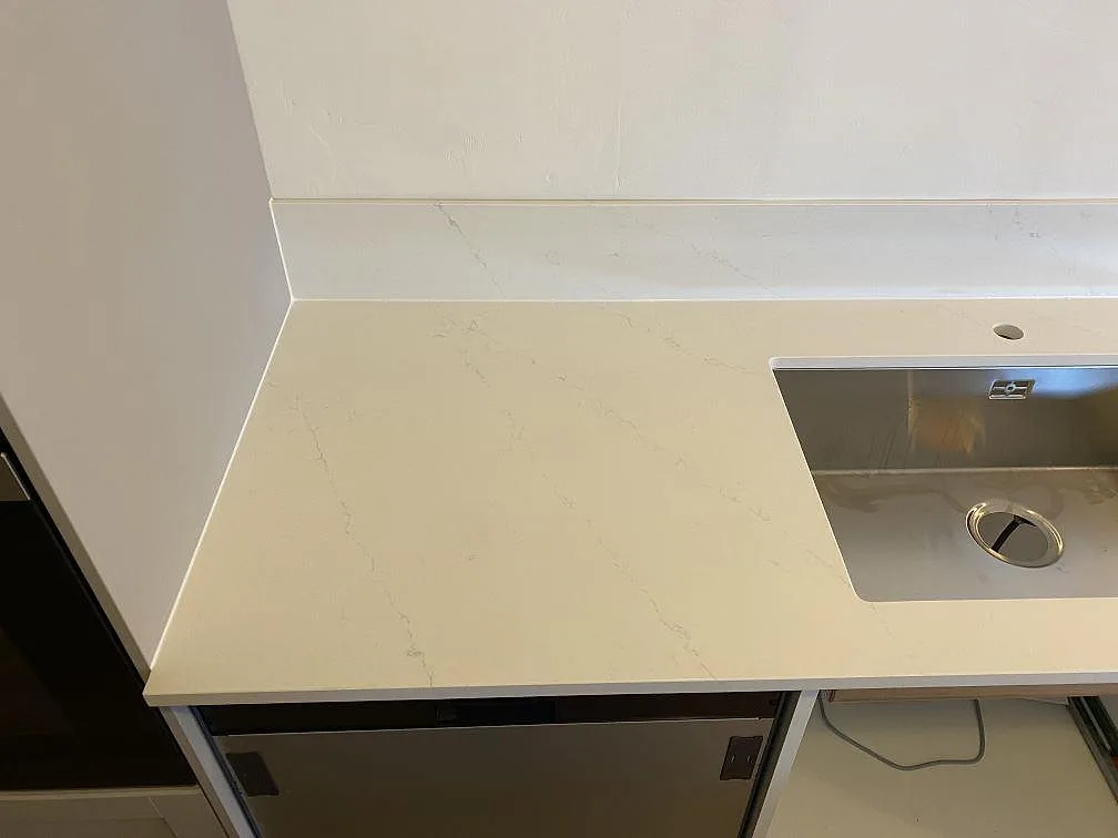 Köksbänkskiva i vit Silestone Eternal Statuario med underlimmad rostfri diskho och uppvikt stänkskydd i Malmö.