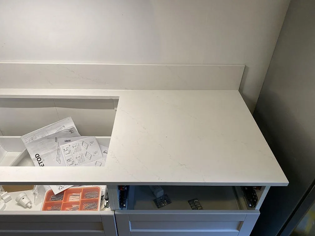 Köksbänkskiva i vit Silestone Eternal Statuario med uppvikt stänkskydd mot vägg i ett kök i Malmö.
