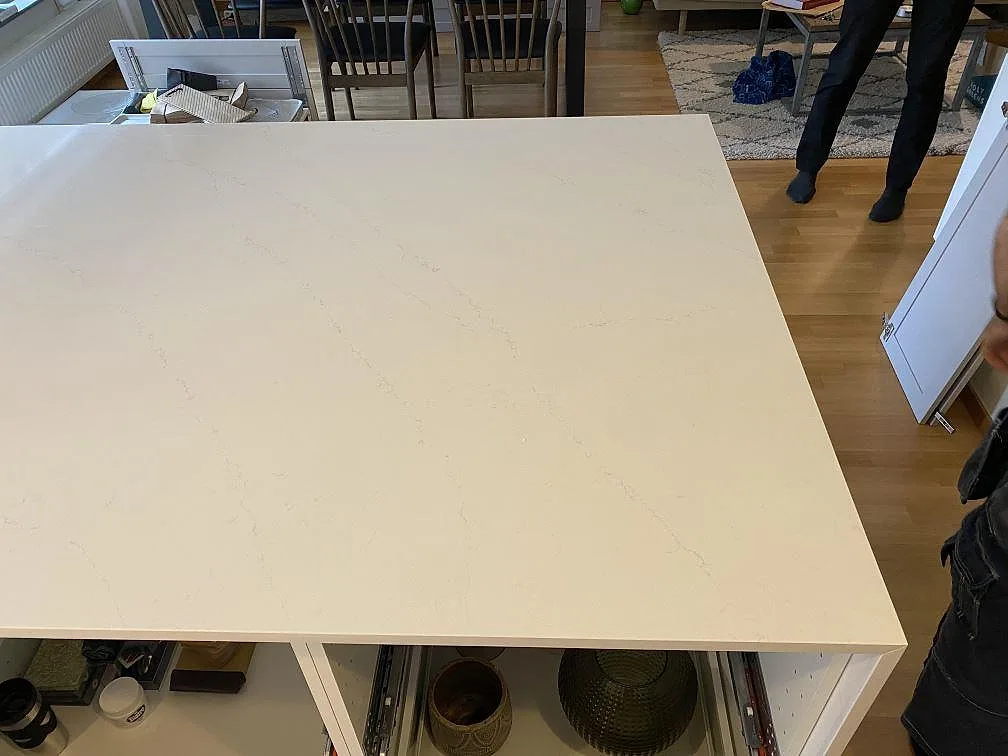 Ovanifrån av köksö i vit Silestone Eternal Statuario med mjuk grå ådring i ett kök i Malmö.