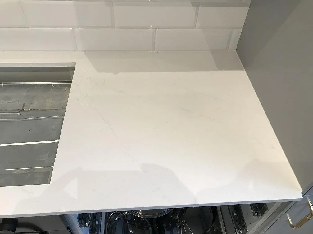 Närbild på den polerade vita Silestone Eternal Statuario med diskret grå ådring i ett kök i Malmö.