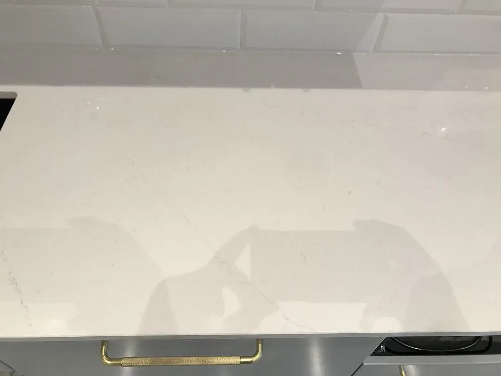 Yta av polerad vit Silestone Eternal Statuario med mjuk grå ådring i ett kök i Malmö.