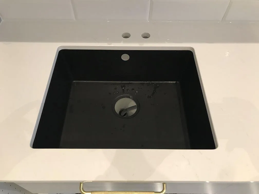 Polerad vit Silestone Eternal Statuario sedd uppifrån med svart underlimmad kompositdiskho i ett kök i Malmö.
