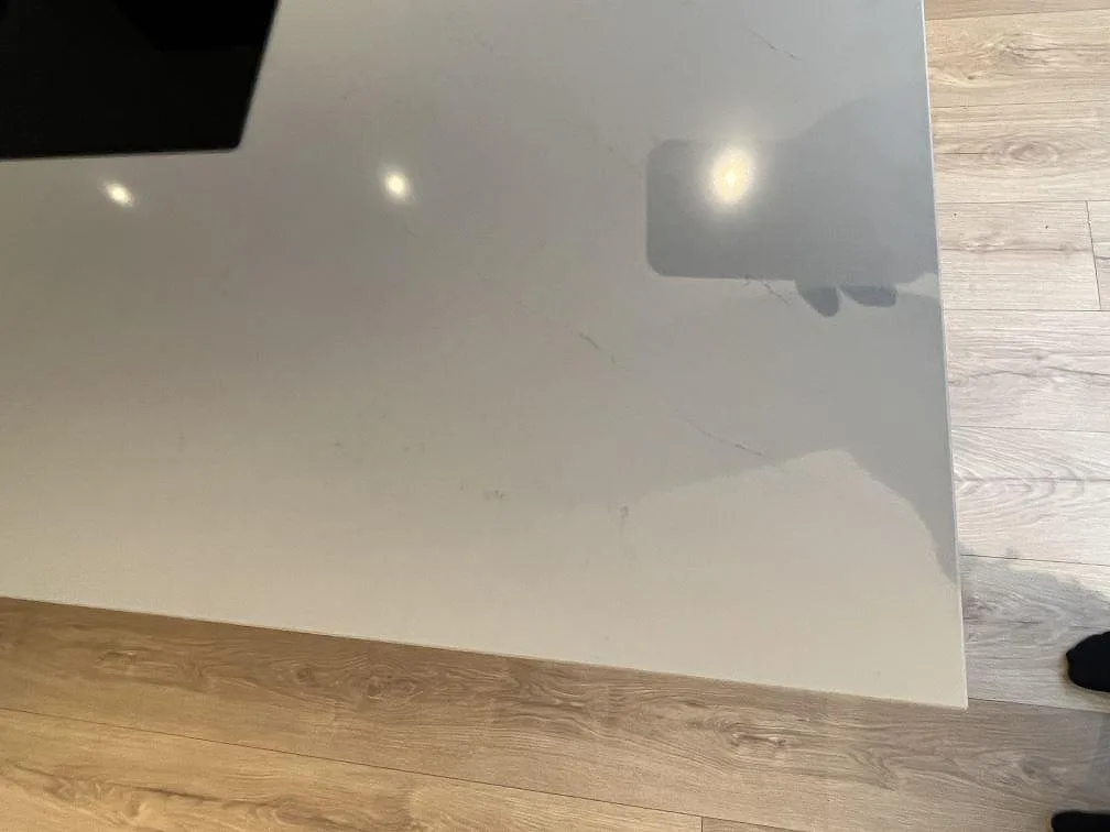 Detalj av köksöns polerade Silestone Eternal Statuario yta med diskret grå ådring och ljust trägolv i Rönninge.