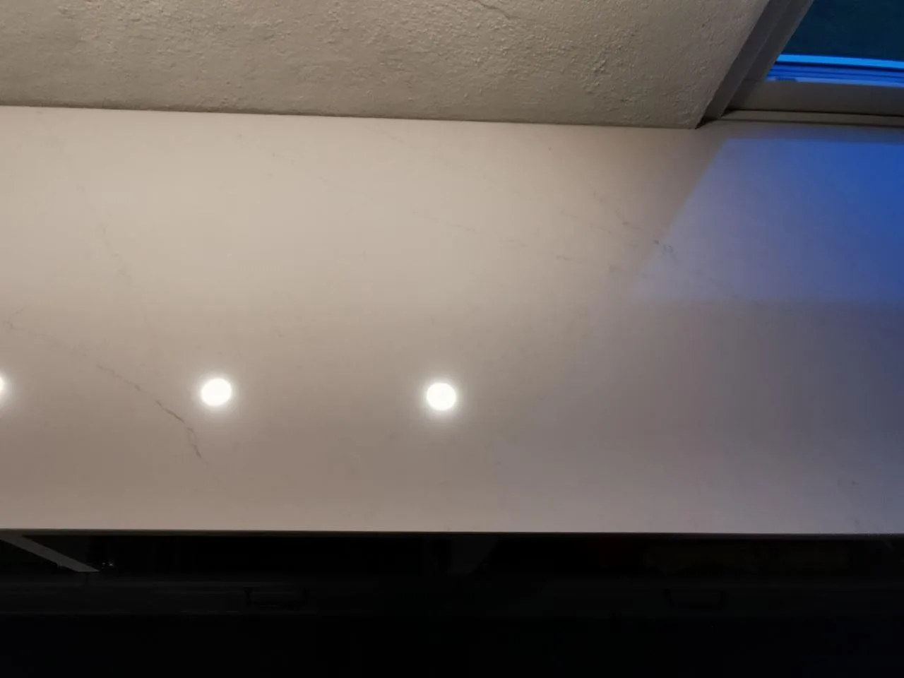Detalj av den polerade ytan i Silestone Eternal Statuario med mjukt grå ådring i ett kök i Trelleborg.