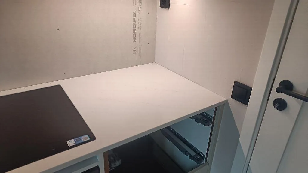 Hörnparti med häll och bänkskiva i polerad Silestone Eternal Statuario över öppna köksstommar i Varberg.