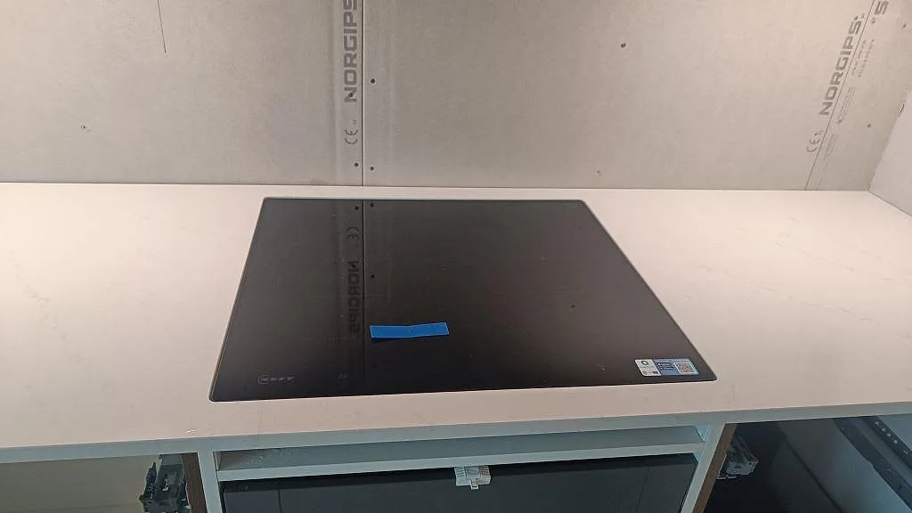 Induktionshäll i en polerad Silestone Eternal Statuario bänkskiva med ljus marmorkänsla i ett kök i Varberg.