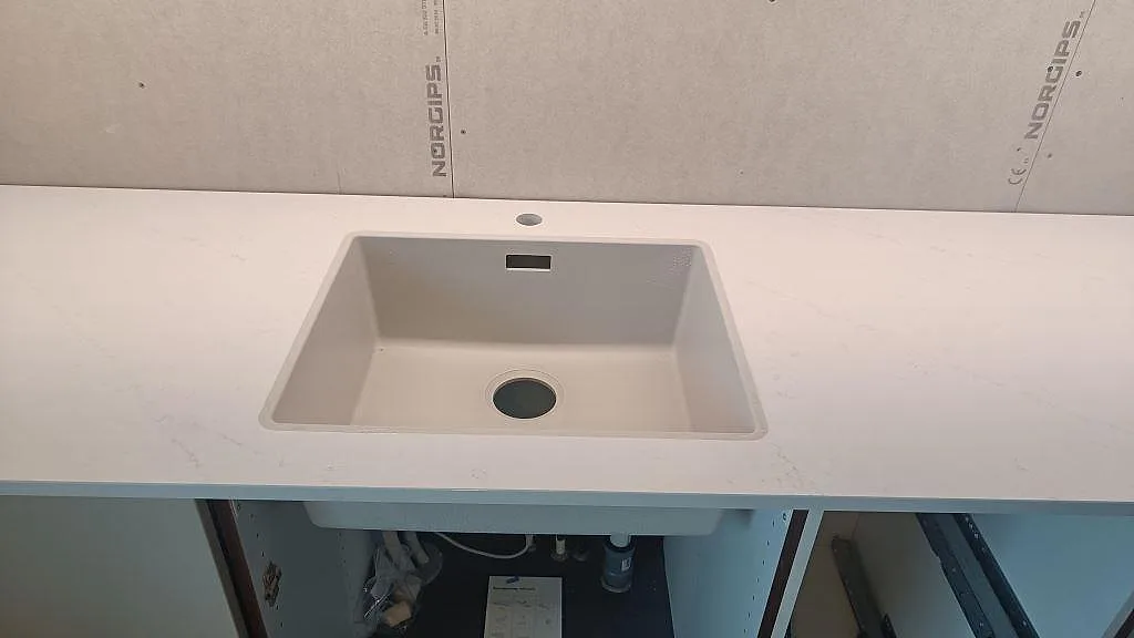 Diskho i en vit köksbänkskiva av polerad Silestone Eternal Statuario med svag grå ådring i Varberg.