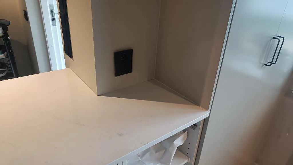 Sidovy av ljus Silestone Eternal Statuario bänkskiva vid högskåp och väggnisch i ett kök i Varberg.