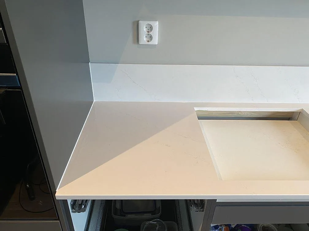 Vit Silestone Eternal Statuario med grå ådring och uppvikt stänkskydd vid en köksbänk i Vellinge.
