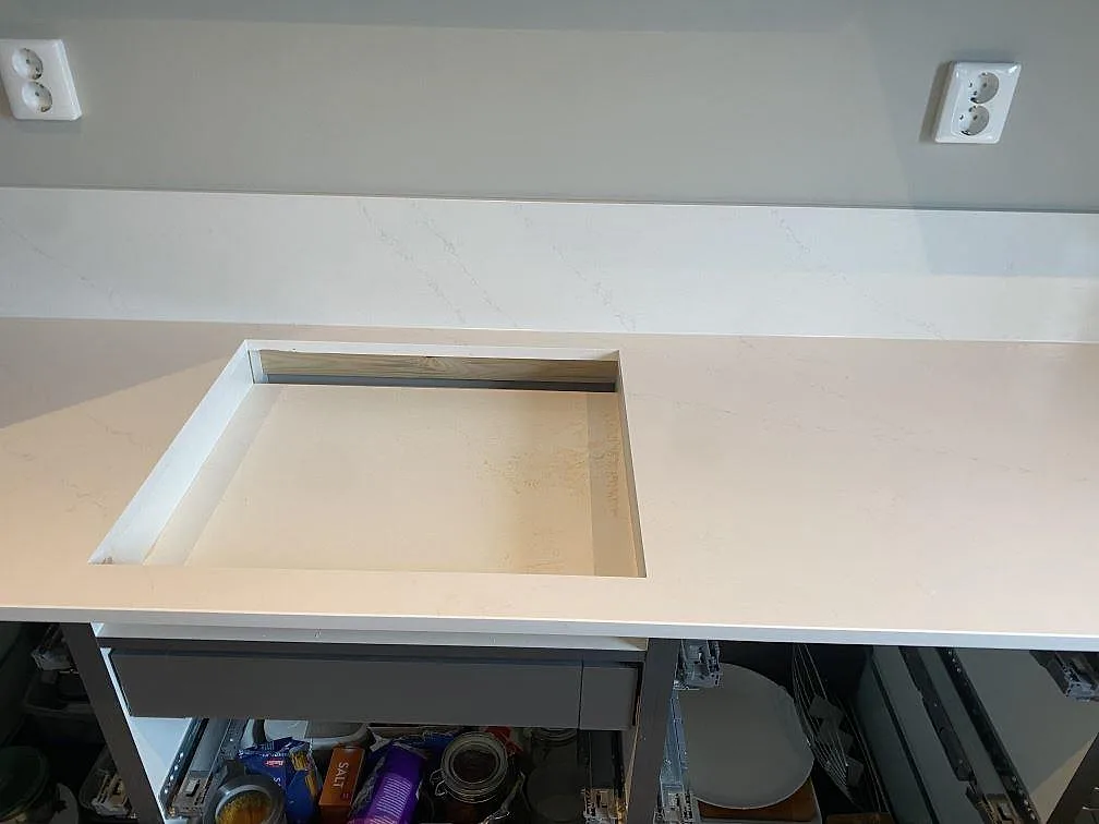 Köksbänkskiva i vit Silestone Eternal Statuario med urtag för häll i ett kök i Vellinge.
