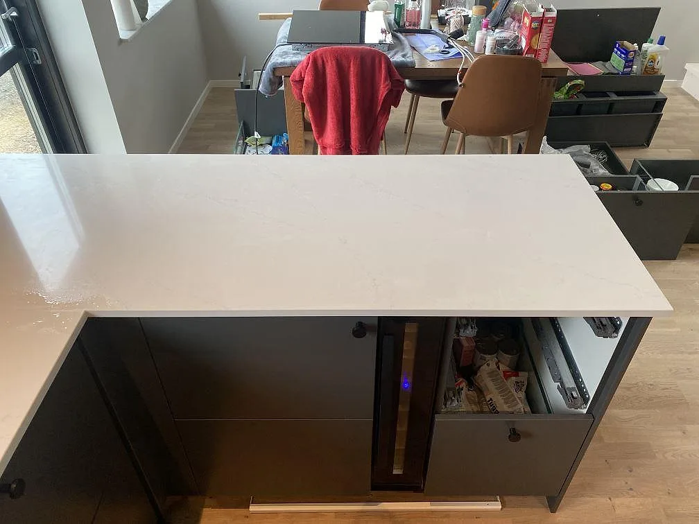 Köksö i vit Silestone Eternal Statuario med polerad yta och diskret Statuario-ådring i ett kök i Vellinge.