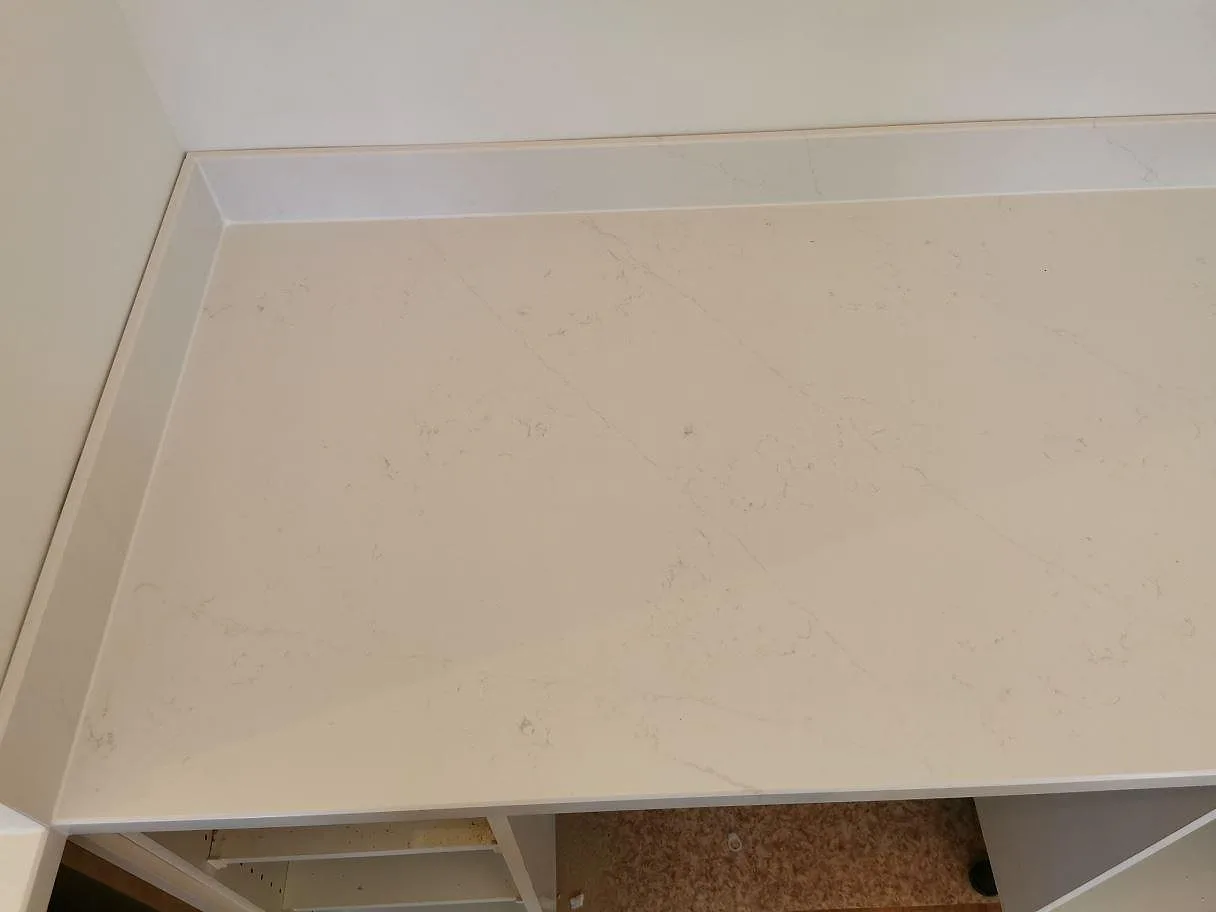 Polerad köksbänkskiva i vit Silestone Eternal Statuario med diskret grå marmorlik ådring, sedd ovanifrån, i ett kök i Ystad.