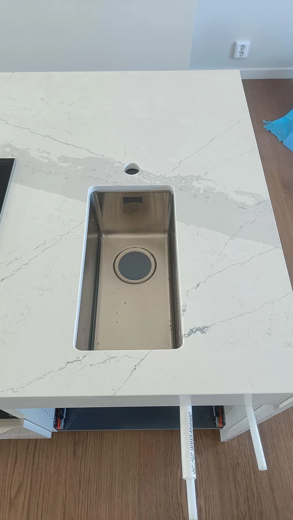 Underlimmad rostfri diskho med blandarhål i vit Silestone Ethereal Dusk, polerad kompositbänkskiva i Halmstad.