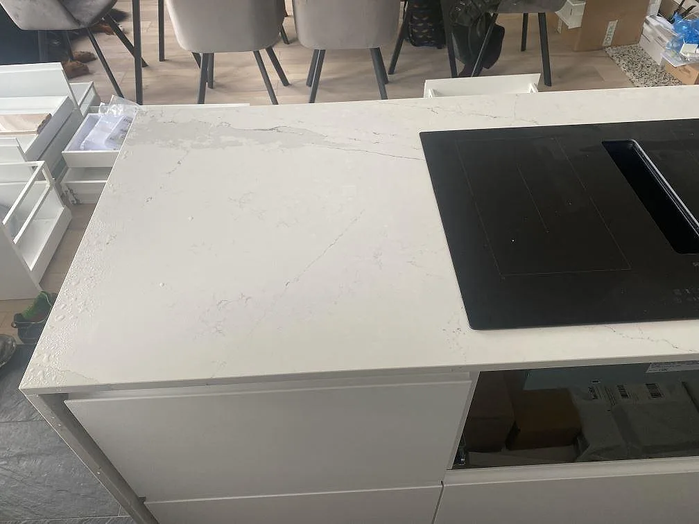 Köksö i Silestone Ethereal Dusk med Siemens induktionshäll och mjuk grå ådring i den polerade kompositytan, kök i Staffanstorp.
