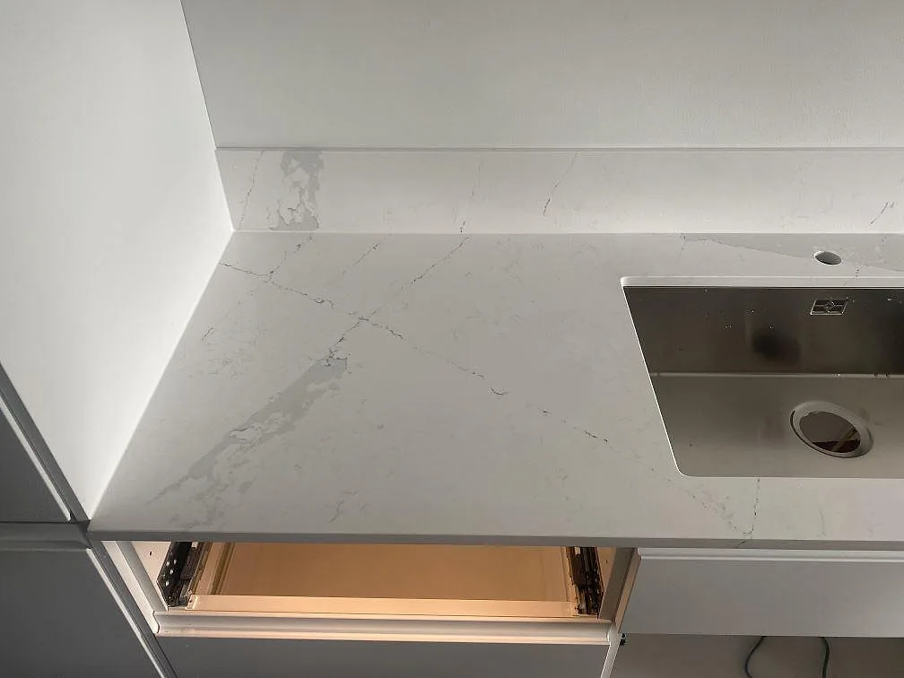 Underlimmad rostfri diskho i ljus Silestone Ethereal Dusk köksbänkskiva, polerad komposit med fin grå ådring, kök i Staffanstorp.
