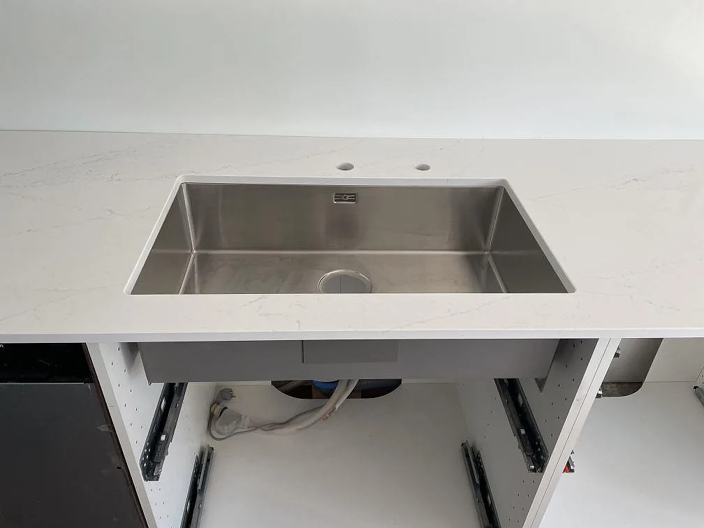Underlimmad rostfri diskho i en polerad Silestone Ethereal Glow köksbänkskiva i Falsterbo.