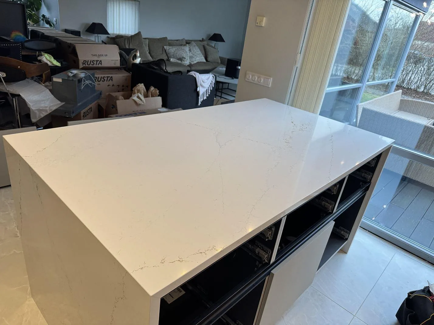 Köksbänkskiva och köksö i vit Silestone Ethereal Glow med mjuk grå ådring, polerad yta och waterfall-kant i ett kök i Lund.