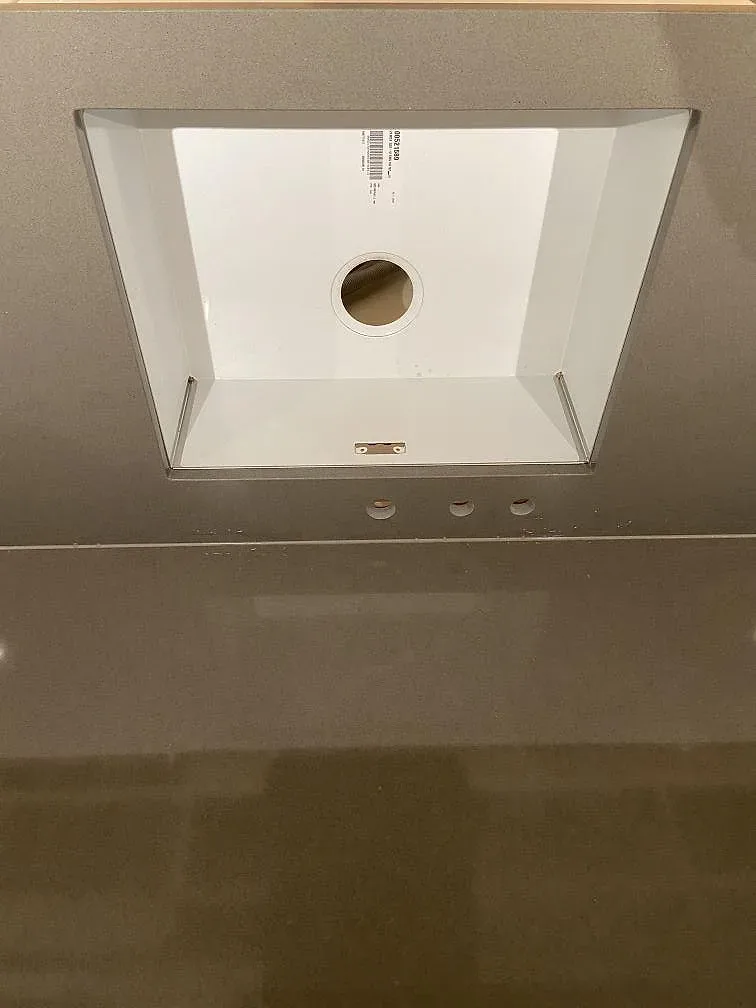 Detalj av urtag för underlimmad rostfri diskho i polerad grå Silestone Gris Expo köksbänkskiva i Mölnlycke.