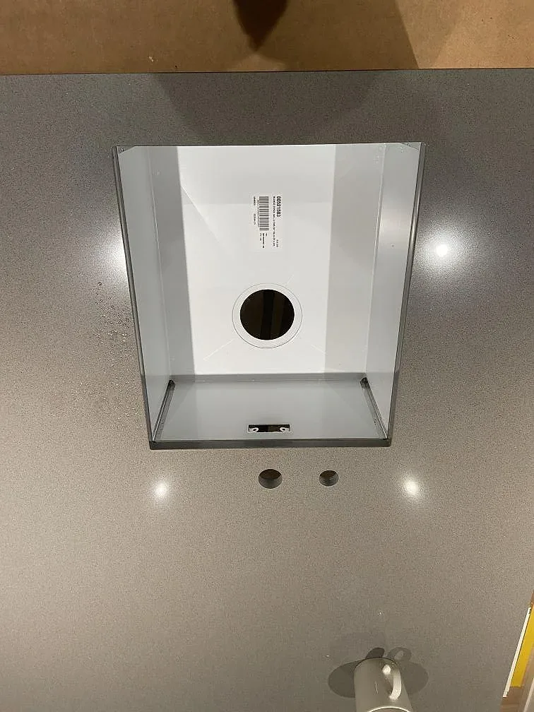 Ovanifrån av urtag för underlimmad rostfri Blanco Zerox-diskho och blandarehål i grå Silestone Gris Expo köksbänkskiva i Mölnlycke.