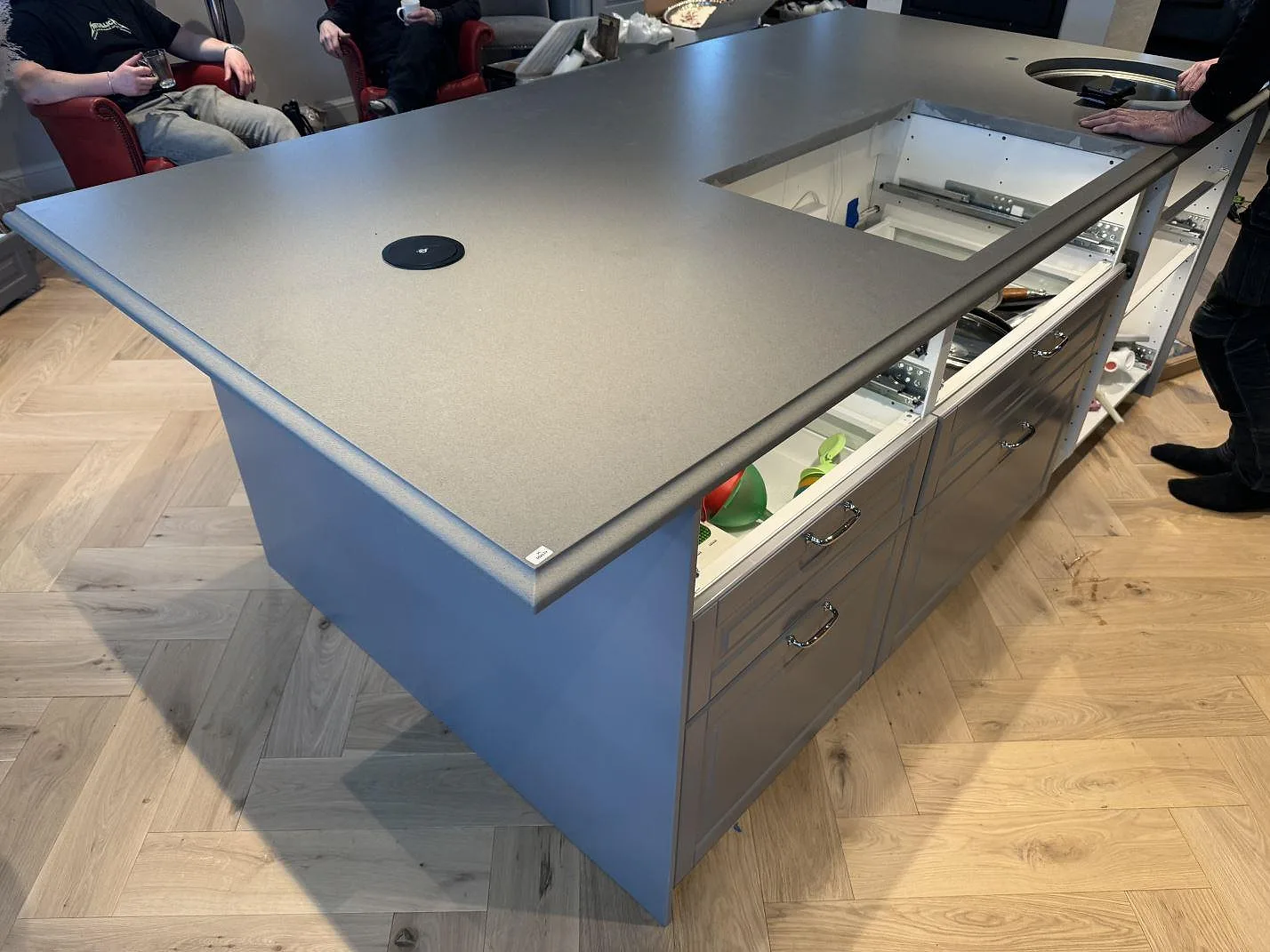 Stor grå köksö i Silestone Gris Expo, 30 mm Mocka, med rund prep-ho och utskärning för häll i ett kök i Sölvesborg.