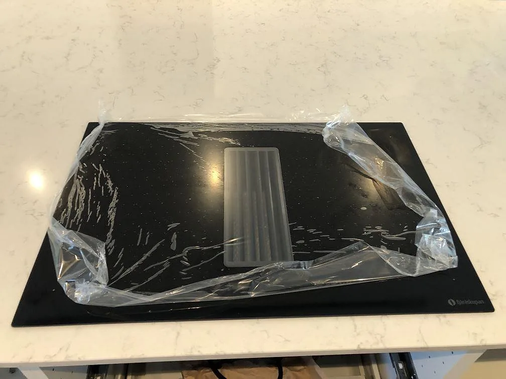 Spishäll placerad ovanpå köksön i polerad Silestone Lagoon i ett kök i Falsterbo.