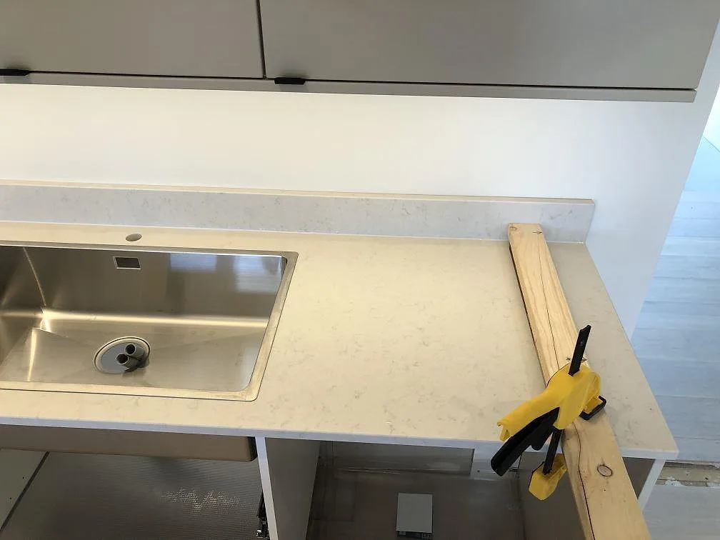 Köksbänk i creme Silestone Lagoon med underlimmad rostfri diskho och separat blandarhål i ett kök i Fjälkinge.