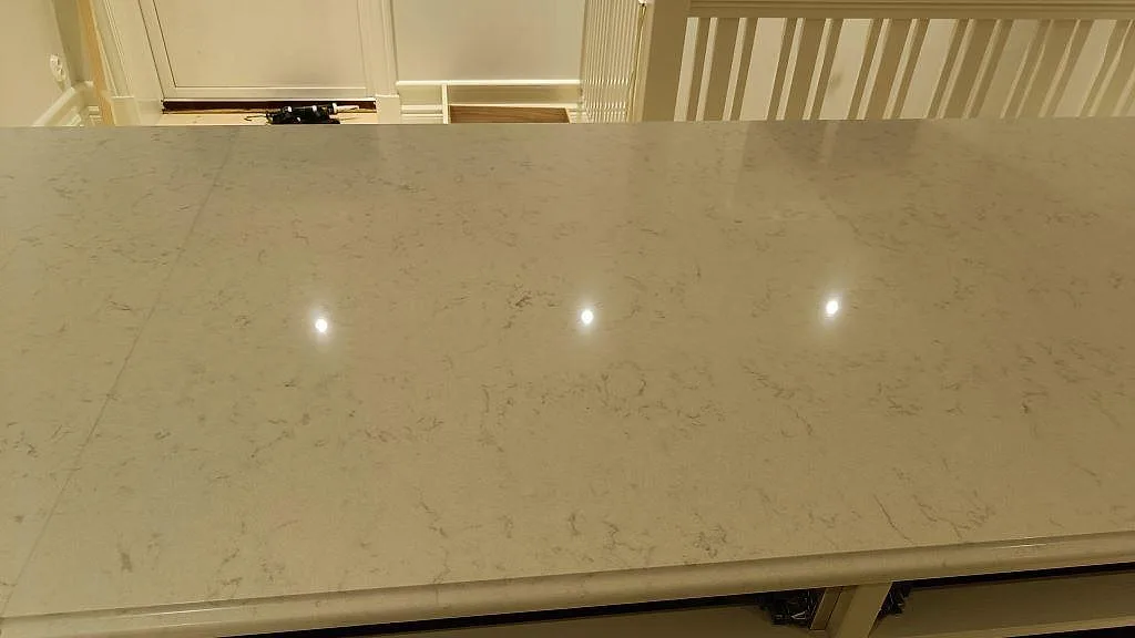 Närbild på polerad Silestone Lagoon köksbänkskiva med ljus grå ådring och profilerad framkant i Lekeryd.