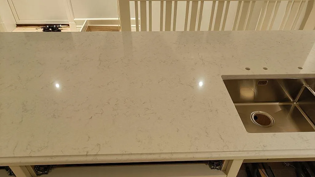 Polerad Silestone Lagoon komposit med rostfri diskho och förborrade blandarhål i ett kök i Lekeryd.