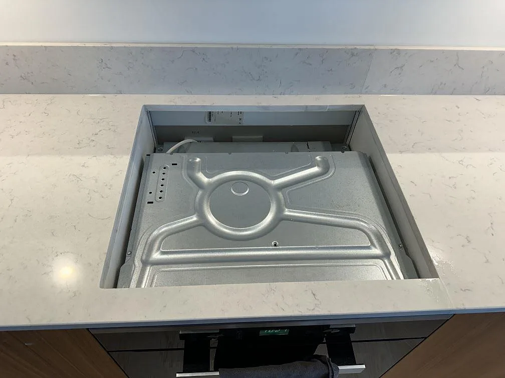 Öppning för häll i en polerad köksbänkskiva av Silestone Lagoon med matchande stänkskydd i Lomma.