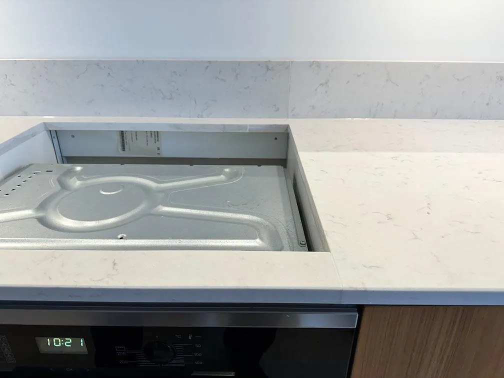 Närbild av hällöppning och grå ådring i en vit Silestone Lagoon köksbänkskiva i Lomma.