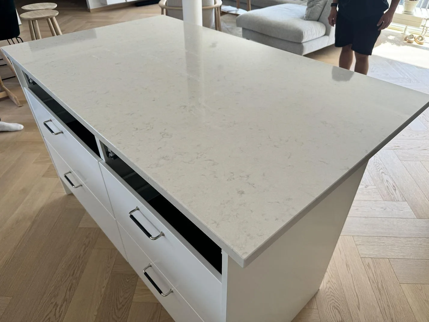 Köksbänkskiva i polerad Silestone Lagoon, vit kvartskomposit, monterad som köksö i ett kök i Malmö.