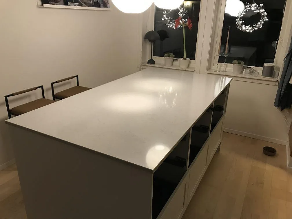 Köksbänkskiva i ljus Silestone Lagoon, polerad kvartskomposit, monterad på öppna stommar i ett kök i Pixbo.