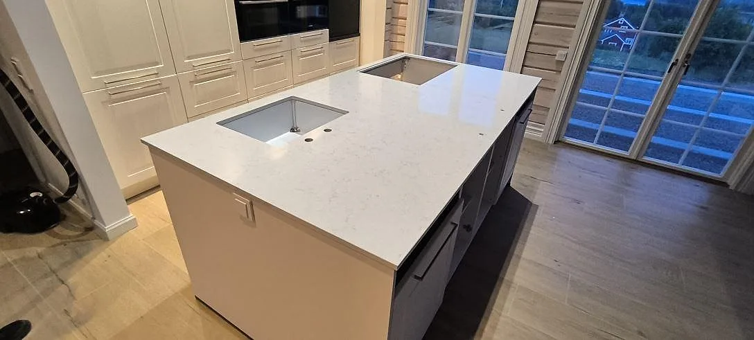 Köksbänkskiva i vit Silestone Lagoon kvartskomposit, polerad, med underlimmad diskho på en köksö i Siljansnäs.