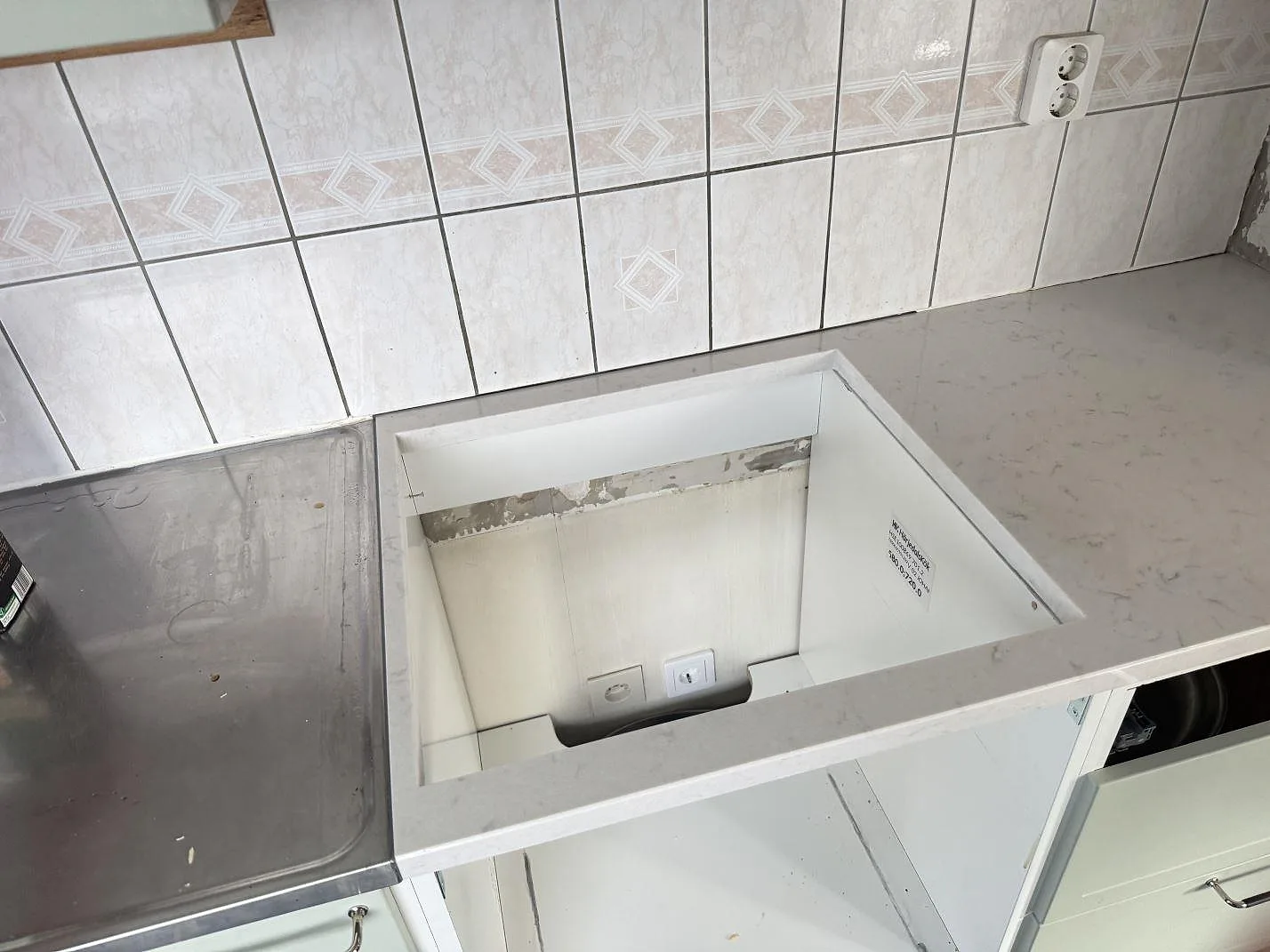 Köksbänkskiva i polerad Silestone Lagoon, 30 mm, med öppet urtag och ljus ådring i kök under montering i Varberg.