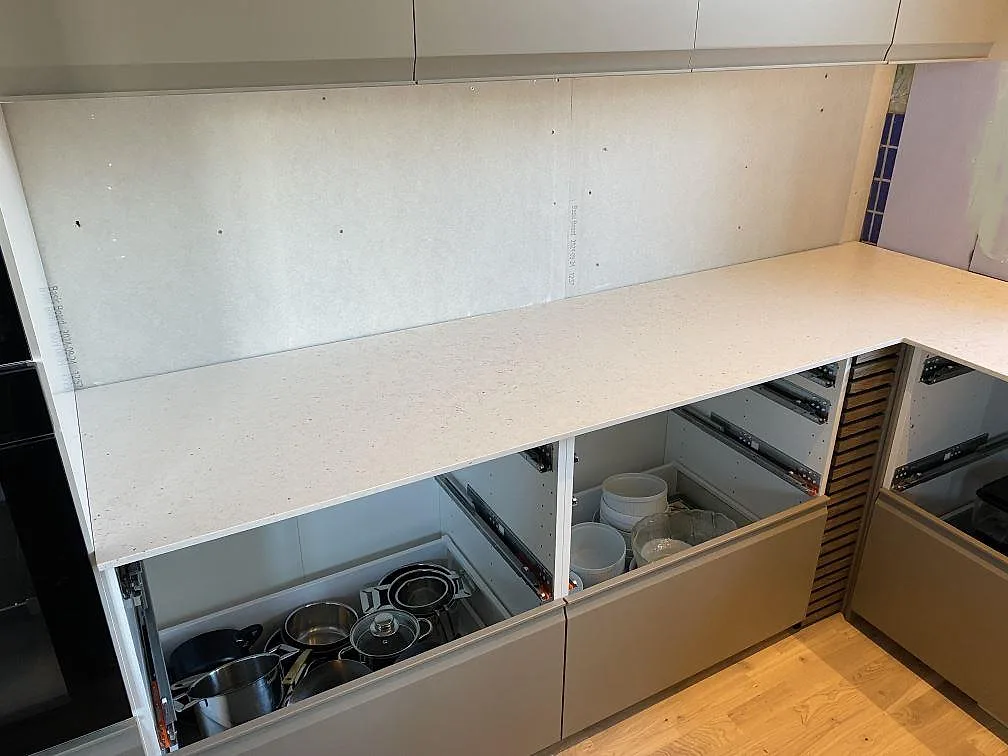 Väggbänk i matt Silestone Lime Delight komposit över öppna köksstommar under montering i Anderslöv.