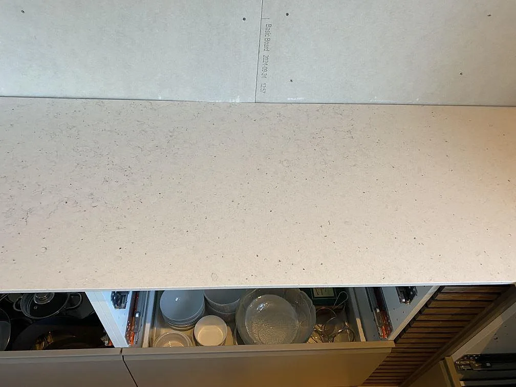 Rak väggbänk i 12 mm Silestone Lime Delight med matt komposityta över öppna stommar i Anderslöv.