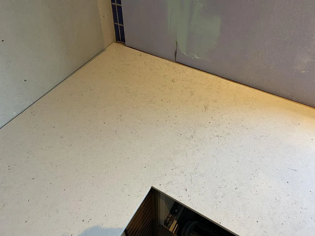 Hörn av köksbänkskiva i Silestone Lime Delight, Mocka, med öppet urtag i ett kök under montering i Anderslöv.