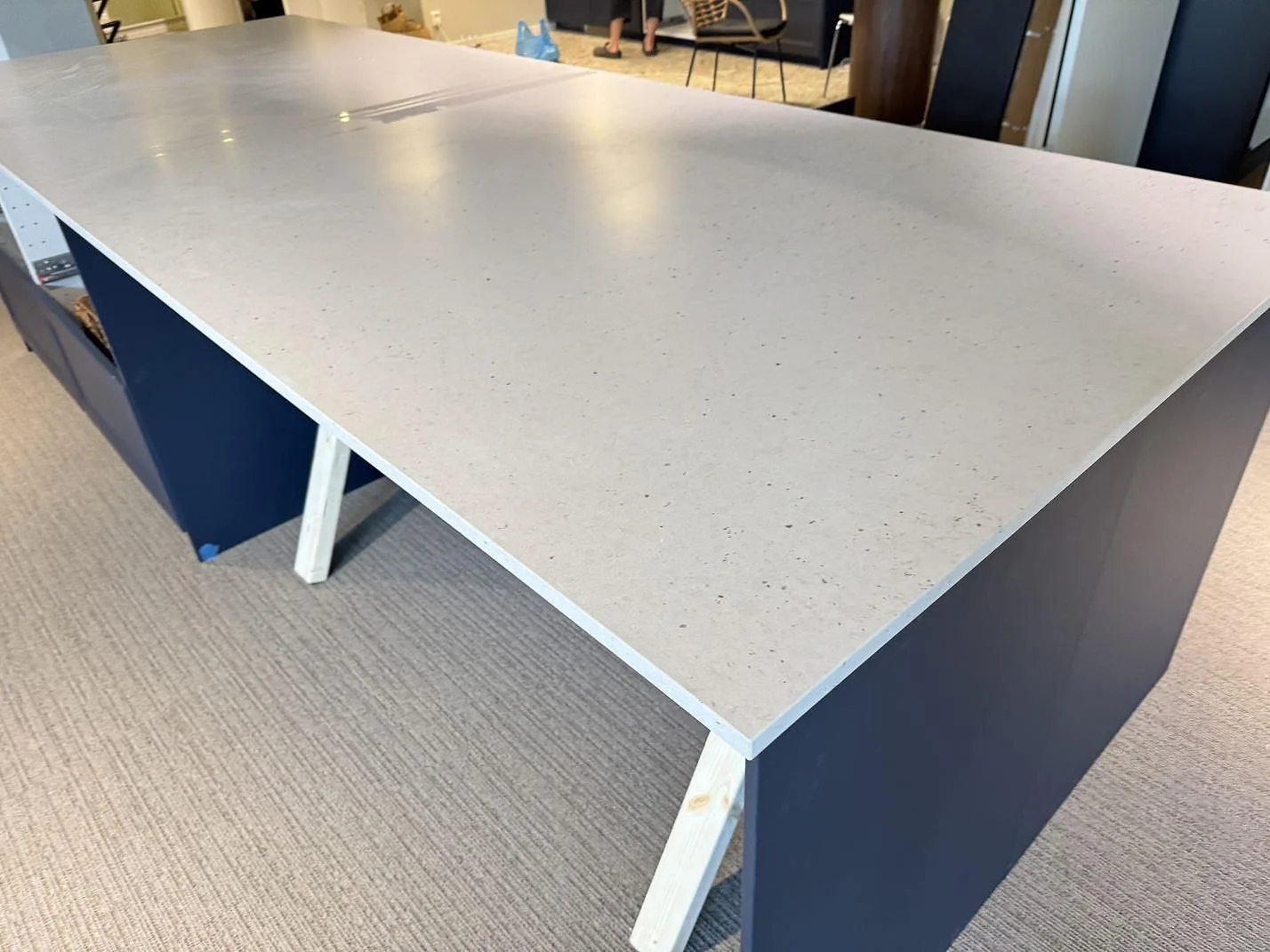Köksbänkskiva i ljus Silestone Lime Delight, matt Mocka-yta, på mörkblå köksstommar under montering i Borås.