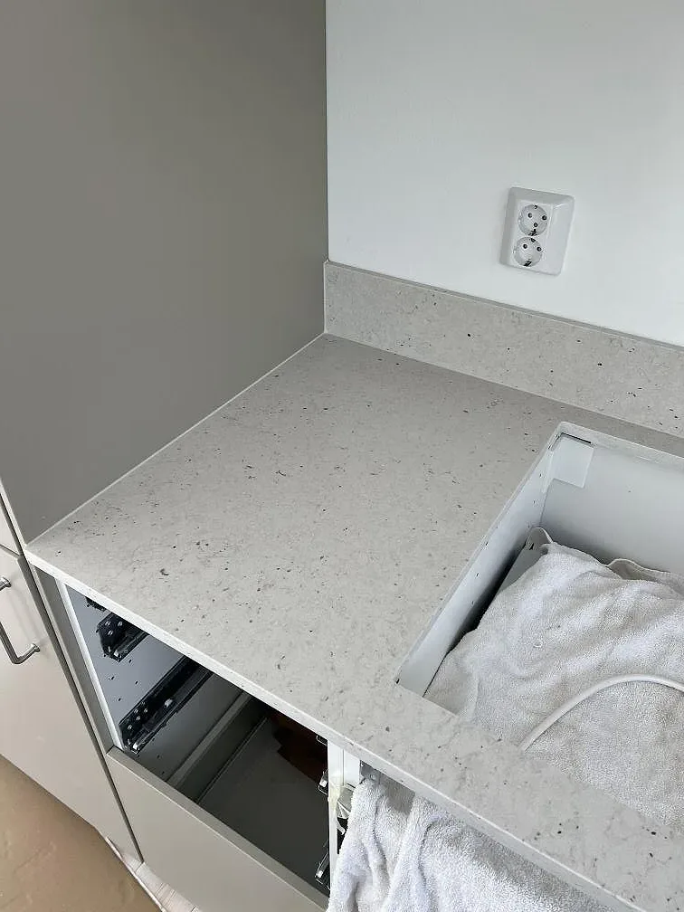 Separat bänkdel i Silestone Lime Delight, matt komposit, med stänkkant, uttag och öppen stomme i Borgholm.