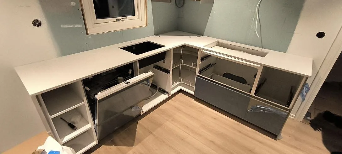 L-formad köksbänkskiva i ljus Silestone Lime Delight, matt Mocka-finish, med synliga urtag i ett kök under montering i Borlänge.
