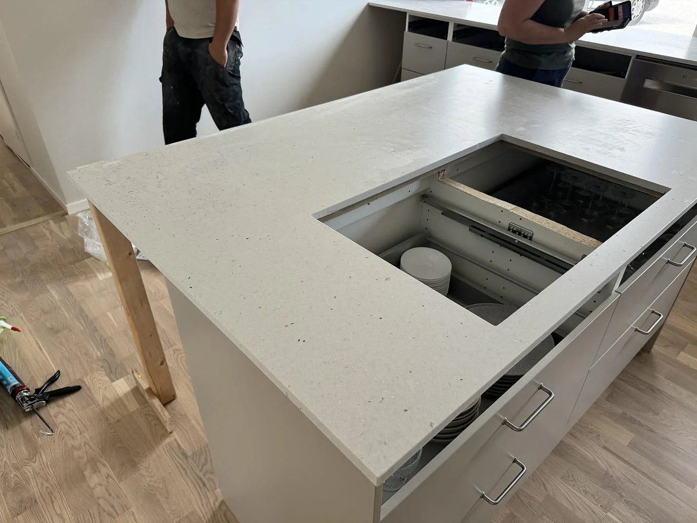 Köksö med bänkskiva i Silestone Lime Delight kvartskomposit, matt Mocka-finish, med öppen utskärning i ett kök i Flyinge.
